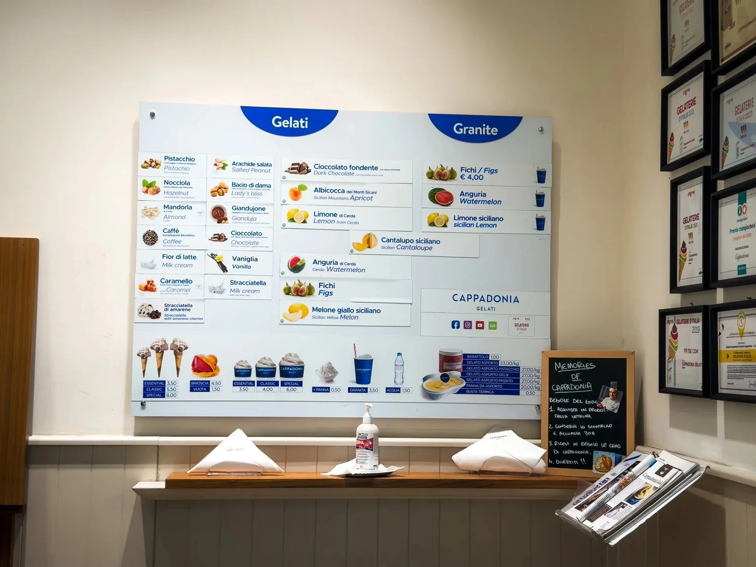 Gelato and granita menu displayed above a shop counter.