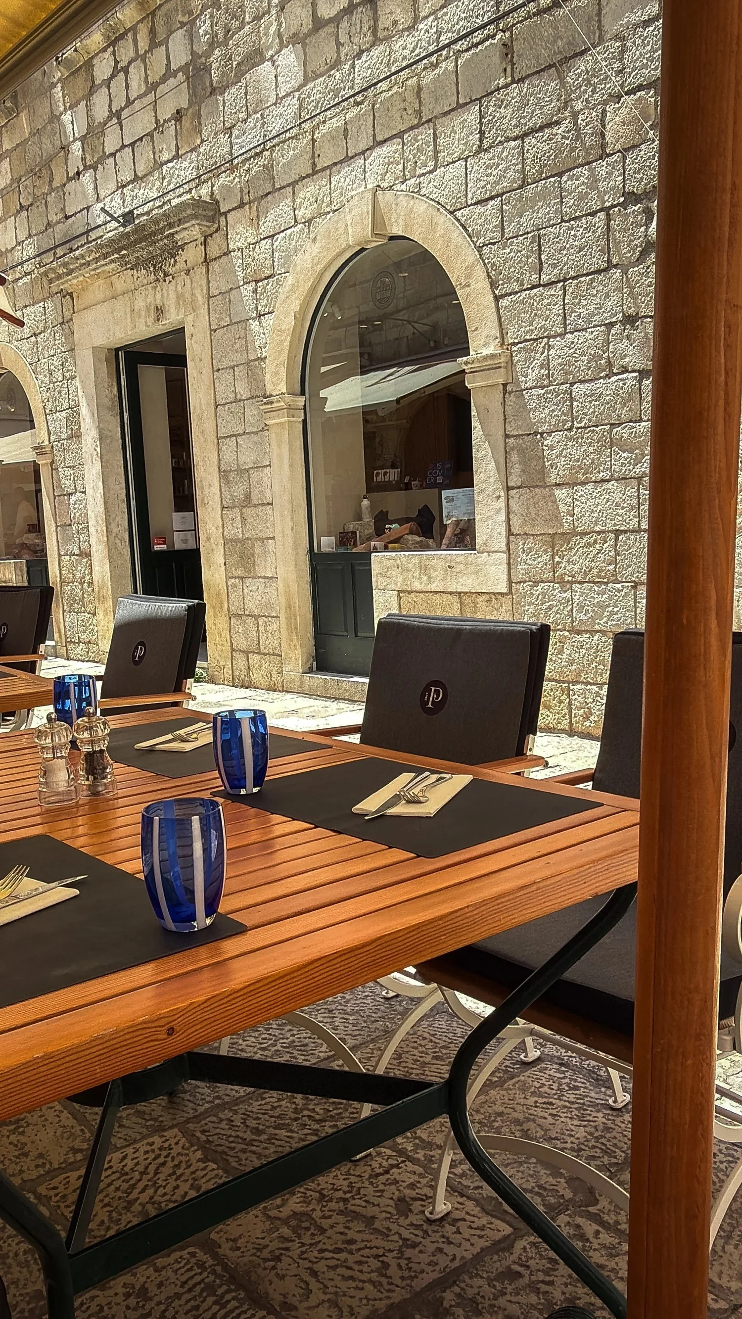 Outdoor table with blue glasses at Fish Restaurant Proto in Dubrovnik