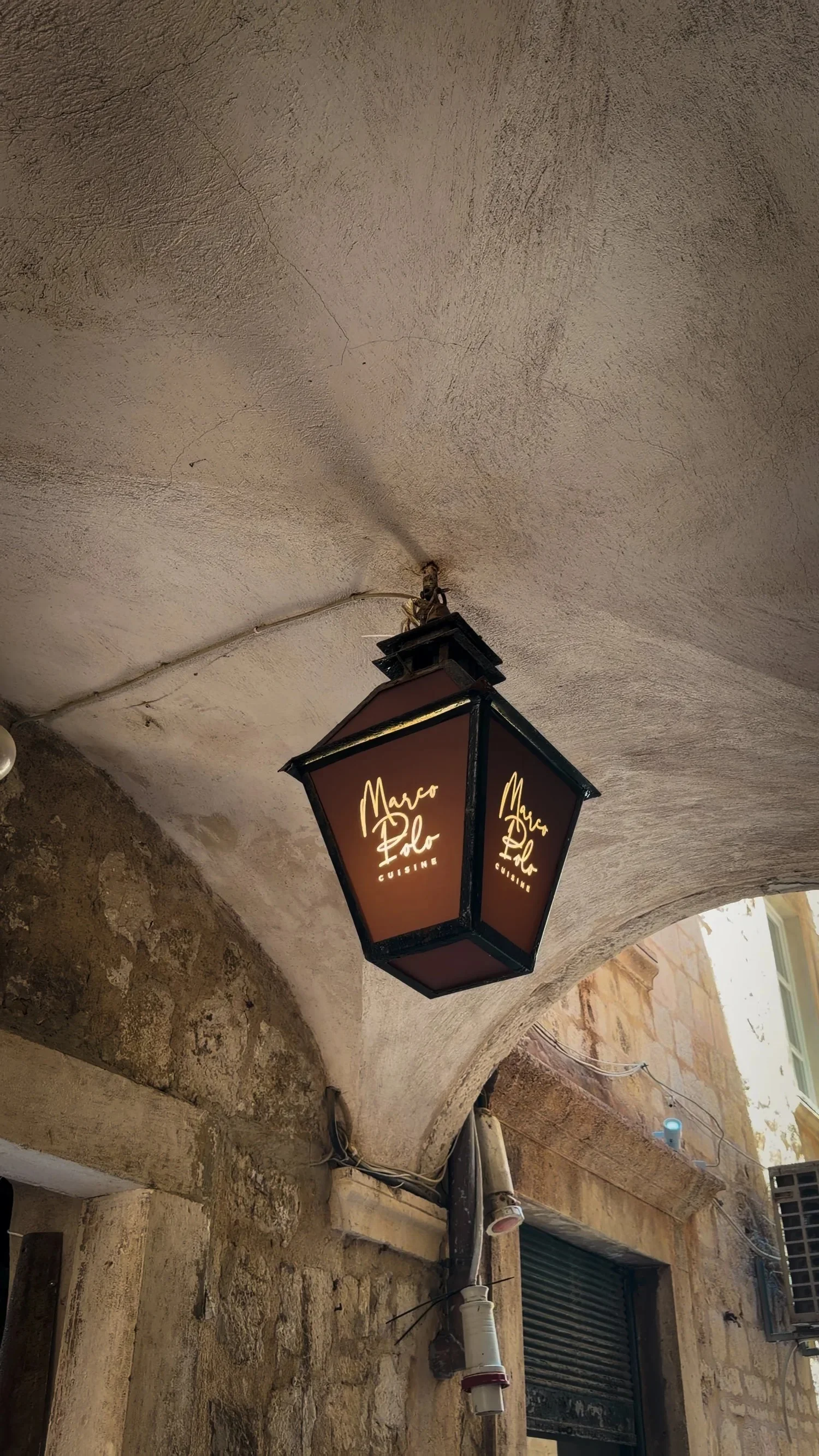 Marco Polo restaurant lantern beneath a stone arch in Dubrovnik Old Town