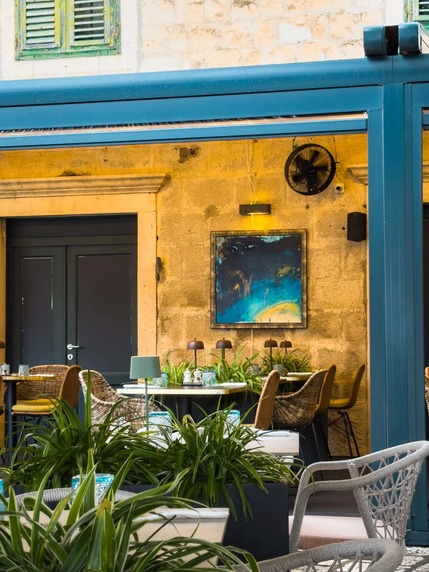 Outdoor tables beneath the blue awning at Restaurant La Bohème