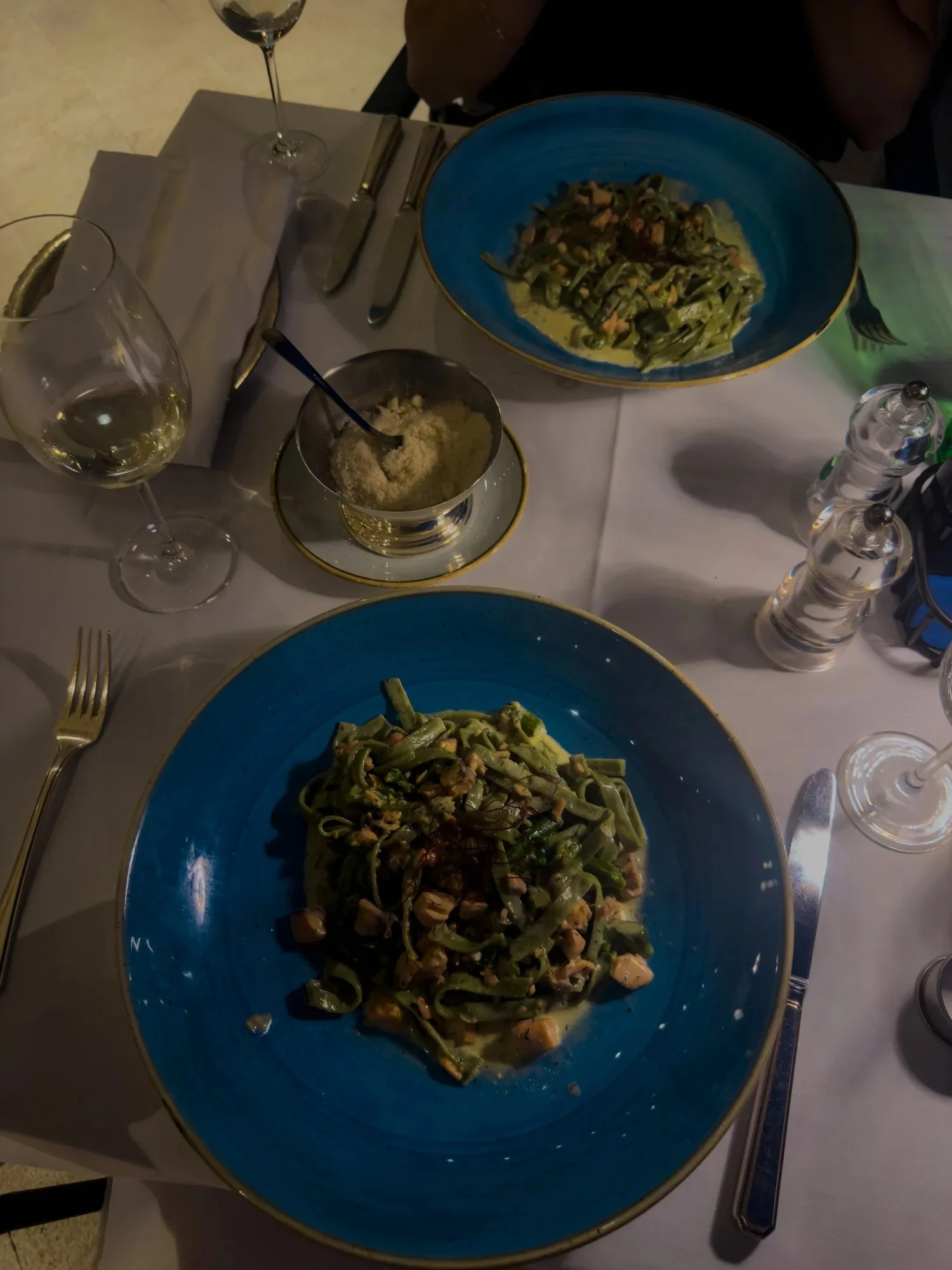 Green tagliatelle served on blue plates at Restaurant More