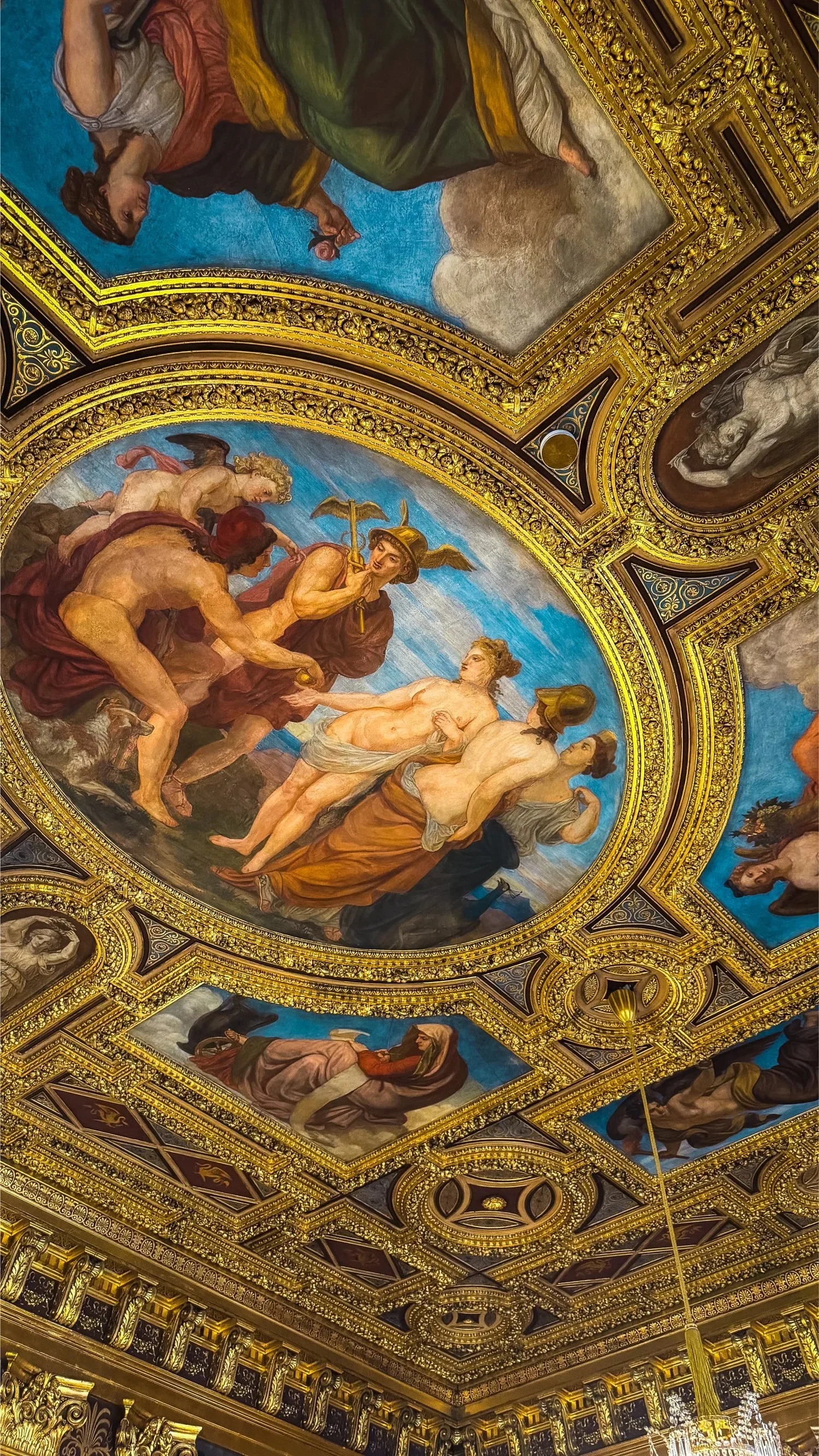 A painted ceiling fresco surrounded by blue and gold decoration.