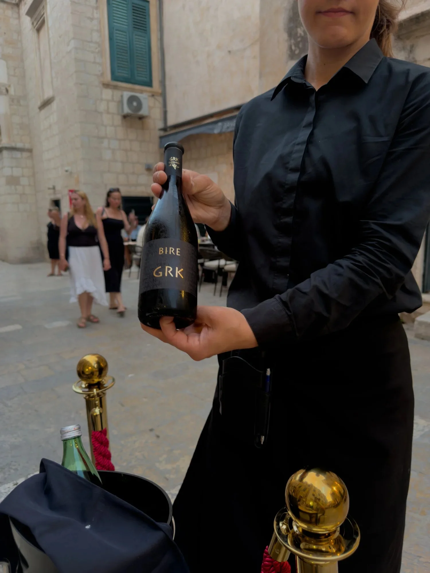 A waiter presenting a bottle of wine at Restaurant Arka in Dubrovnik