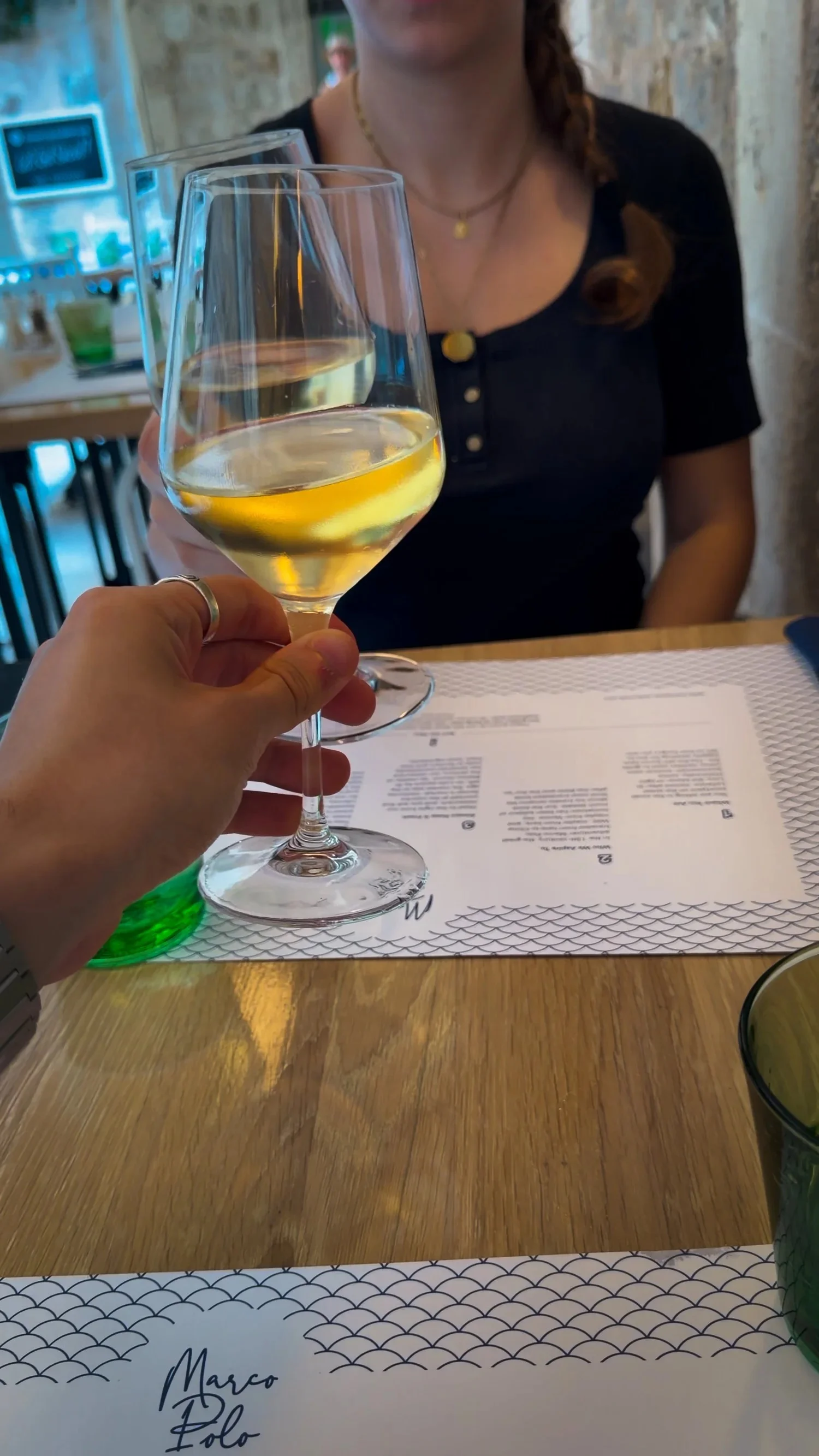 A glass of white wine at an outdoor table at Restaurant Marco Polo